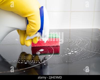 Washes the electric stove. Kitchen cleaning. Dirty electric stove. Stock Photo