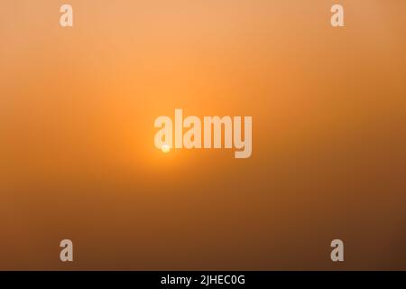 rising sun on clear golden gradient sky without horizon, minimalistic composition Stock Photo