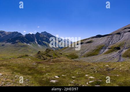 Aerial view towards the high mountains of the Greina plateau in Blenio, Swiss Alps. A rocky ridge on the right leads the eye towards the hilly valley. High quality photo. Stock Photo