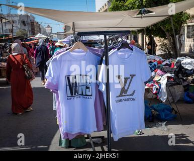 Fake Louis Vitton and Vans t-shirts for sale in the Sunday Souk, a weekly market in Sousse, Tunisia. Stock Photo