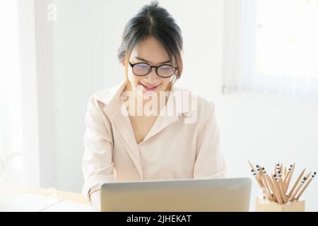 new normal, a businesswoman useing computer to work for a company Via the internet on your desk at home., vintage effect. Stock Photo