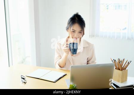 new normal, a businesswoman useing notebook and computer to work for a company Via the internet on your desk at home Stock Photo