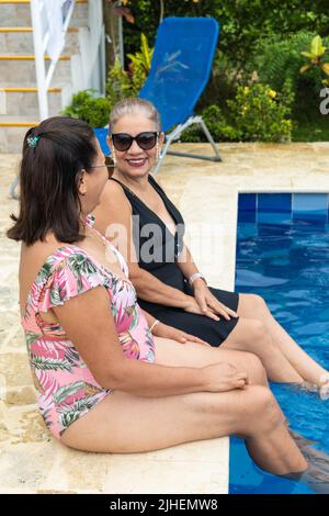Two Older Women Having Fun At The Pool Stock Photo