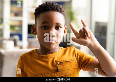 Image of smiling african american boy using sign language Stock Photo