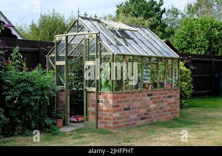 modern, victorian style greenhouse in english garden, norfolk, england Stock Photo