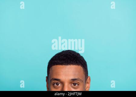 Photo of attractive funky young man peek empty space isolated turquoise color background Stock Photo