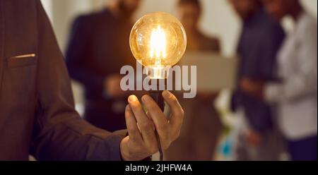 Businessman holding light bulb as concept of creative idea, business innovation, and success Stock Photo