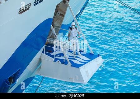 Ship's officer standing on the mooring plaform to oversee the safety of the berthing of this cruise liner Stock Photo