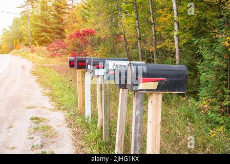 Row of old metal mailboxes along a country road in autumn Stock Photo