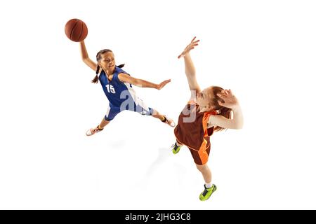 Aerial view of female basketball players, young girls, teen playing basketball isolated on white background. Concept of sport, team, enegry Stock Photo