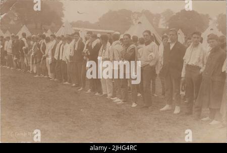 Officer Training Corps (OTC) camp, Hagley Park, Rugeley, Staffordshire, August 1914. Row of young men in civilian clothes with bell tents in the background. The photograph was taken during the first month of the First World War and shows early volunteers for Kitchener's Army Stock Photo