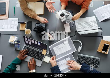 High angle view of team of developers testing new application for virtual reality glasses at table during a meeting Stock Photo