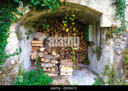 Log store with chopped logs stacked in log store in garden Loire Valley France Stock Photo