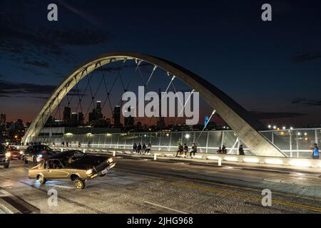 Lowrider car with modified hydraulic suspension shown entertaining passers-by at dusk on the newly inaugurated 6th Street Viaduct in Los Angeles. Stock Photo