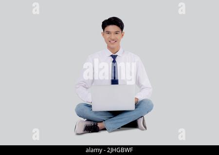 Young asian business man sitting work on laptop computer to internet online isolated on white background, businessman confident and notebook, freelanc Stock Photo