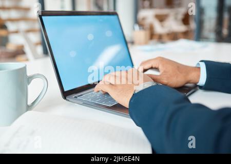 Closeup of a mixed race businessman typing an email on a laptop alone at work. One hispanic male businessperson working on a laptop in an office at Stock Photo