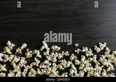 Border of freshly popped popcorn on a dark wood background with copy space Stock Photo
