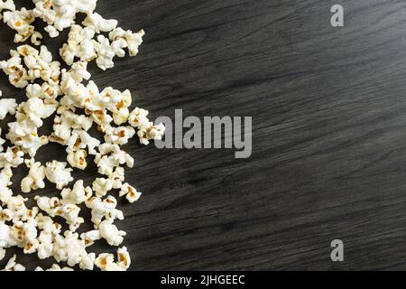 Border of freshly popped popcorn on a dark wood background with copy space Stock Photo
