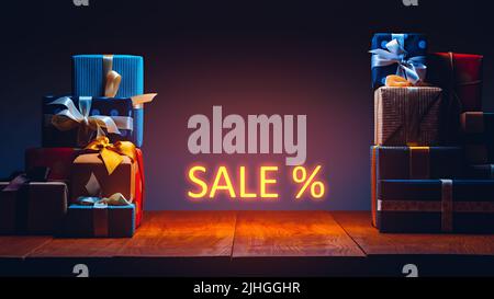 Gift boxes on the table in neon lighting. Sale concept Stock Photo