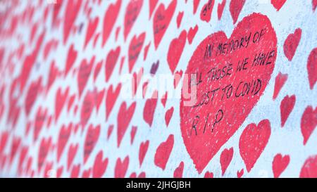 London, UK - March 30, 2021: The National Covid Memorial Wall, volunteers painting 150,000 red hearts to commemorate Covid-19 deaths Stock Photo