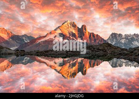 Colourful sunset on Lac Blanc lake in France Alps. Monte Bianco mountain range on background. Vallon de Berard Nature Preserve, Chamonix, Graian Alps. Landscape photography Stock Photo