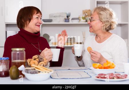cheerful mature females talking and drinking tea Stock Photo