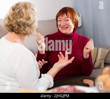 Smiling mature lady with female friend at home Stock Photo
