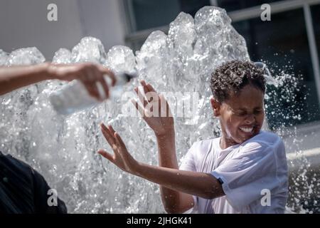 London, UK. 18th July, 2022. UK Weather: Heatwave Monday. Locals cool off in the Wembley Park water fountains as temperatures continue to rise with an amber alert in place for extreme heat. Britain could soon experience its hottest day as Met Office predicts Britain could hit 41C high. Credit: Guy Corbishley/Alamy Live News Stock Photo