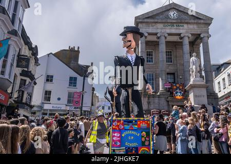 People carrying large withy and paper figures of Rude Boys Figures in the parade in the Mazey Day celebrations as part of the Golowan Festival in Penz Stock Photo