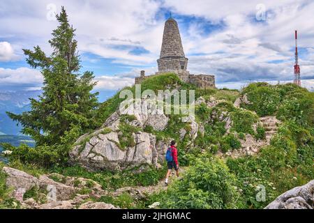 nice senior woman hiking at Mount Gruenten in the Allgaeu Alps with awesomw view over Iller valley to Lake Alpsee and Lake of Constanz, Bodensee,  Bav Stock Photo