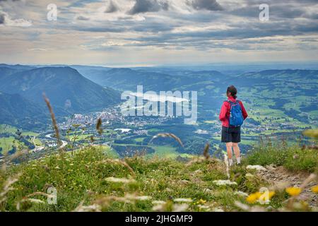 nice senior woman hiking at Mount Gruenten in the Allgaeu Alps with awesomw view over Iller valley to Lake Alpsee and Lake of Constanz, Bodensee,  Bav Stock Photo