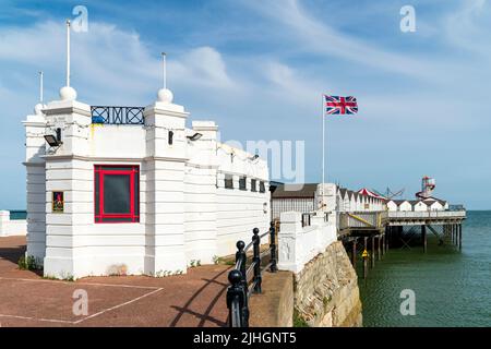 The small white office building at the entrance to the pier at the Kent resort town of Herne Bay in the early morning on a summer's day. Blue sky. Stock Photo