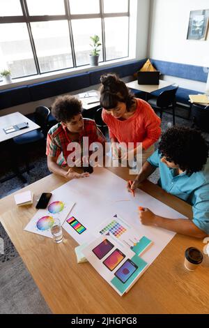 Creative multiracial male and female colleagues discussing business plan in office Stock Photo