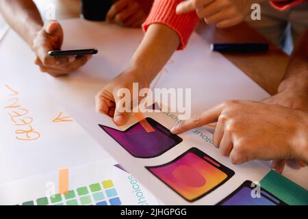 Creative multiracial design professionals discussing over charts in office Stock Photo