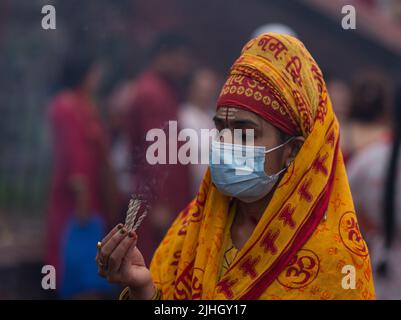 Kathmandu, Nepal. 18th July, 2022. Nepalese Hindu devotee offers incense to Lord Shiva during the first day of the Sharwan Brata Festival. During the month of Shrawan, each Monday Nepalese Hindu women worship Lord Shiva for a long and prosperous life for their husband or to get a good one. Credit: SOPA Images Limited/Alamy Live News Stock Photo