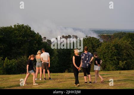 People watch a large wildfire that has broken out in woodland at Lickey Hills Country Park on the edge of Birmingham. About sixty firefighters are tackling the blaze which broke out at the beauty spot earlier today. Picture date: Monday July 18, 2022. Stock Photo