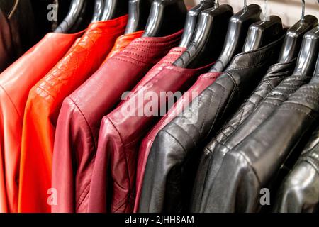 Colourful leather jackets in red and black hanging on a rail Stock Photo