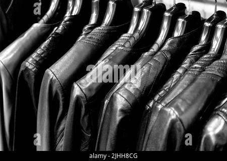 Colourful leather jackets in red and black hanging on a rail Stock Photo