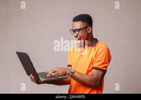 excited boy isolated over white using his laptop Stock Photo