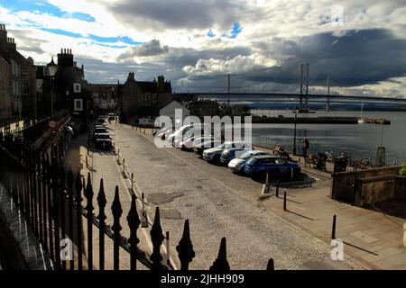 Scottish town, Sunlit street along East Terrace, with the Forth Bridges in the background, South Queensferry, Scotland, UK Stock Photo