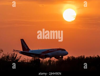 Easy Jet plane lands during sunset at Luton Airport after a small section of the runway had lifted due to high temperatures this afternoon Stock Photo