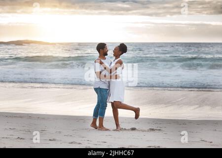 Playful african american couple spending a day at the sea together. Carefree boyfriend and girlfriend dancing on the beach. Caring husband and wife Stock Photo
