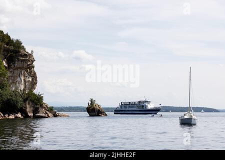 The Spirit of Ethan Allen tourist cruise ship and a sailboat by Lone Rock Point on Lake Champlain in Burlington, Vermont, USA. Stock Photo