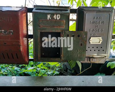 Old metal mailboxes. The inscription on the boxes in Russian from left to right Mail, apt. 10, For letters and newspapers, apt., Correspondence is del Stock Photo