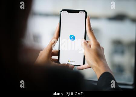 CHIANG MAI, THAILAND - April 06 ,2021: Woman holding iphone with skype apps. Skype is part of Microsoft, can make video, audio calls, chat messages Stock Photo