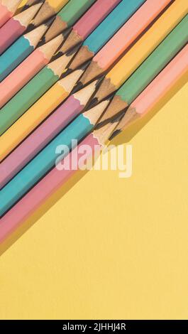 Colored wooden pencils on yellow background. Top view with copy space. Flat lay. Back to school concept. Stock Photo