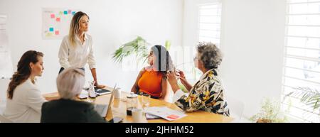 Creative businesswomen having a discussion during a boardroom meeting. Group of multicultural businesswomen brainstorming in an office. Diverse busine Stock Photo