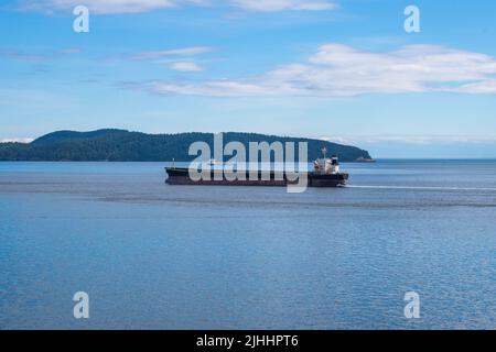 Bulk carrier passing through Swanson Channel, North Pender Island, British Columbia, Canada Stock Photo
