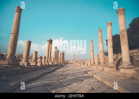 A view looking down the Cardo showing stone carved columns and paved street at the ancient city of Jarash or Gerasa, Jerash in Jordan. ancient Roman s Stock Photo