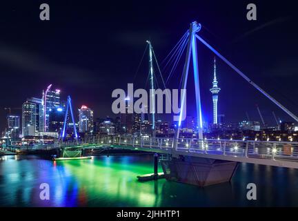 Auckland, New Zealand, at night, seen from the bridge crossing Viaduct Basin. To the right is the iconic Sky Tower Stock Photo